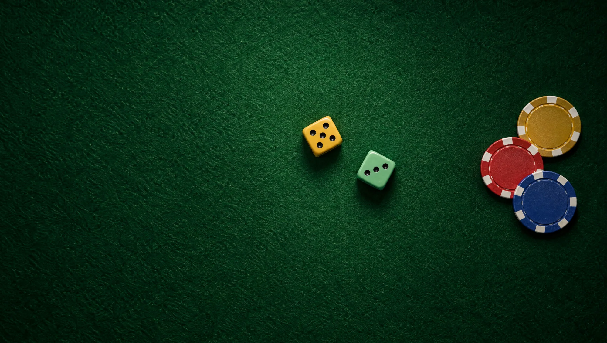 Two dice and three clay chips on green felt